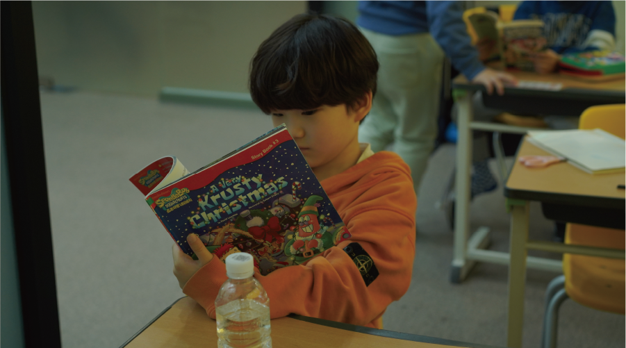 JCS Elementary English Elementary school student reading an English textbook during a regular curriculum English class